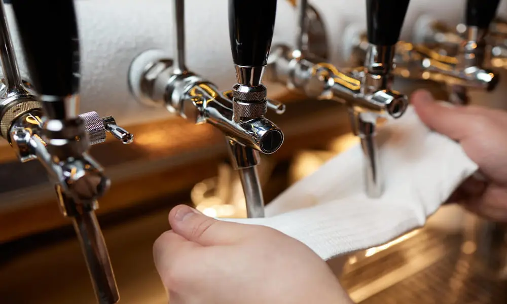 Cleaning beer taps during bar maintenance.
