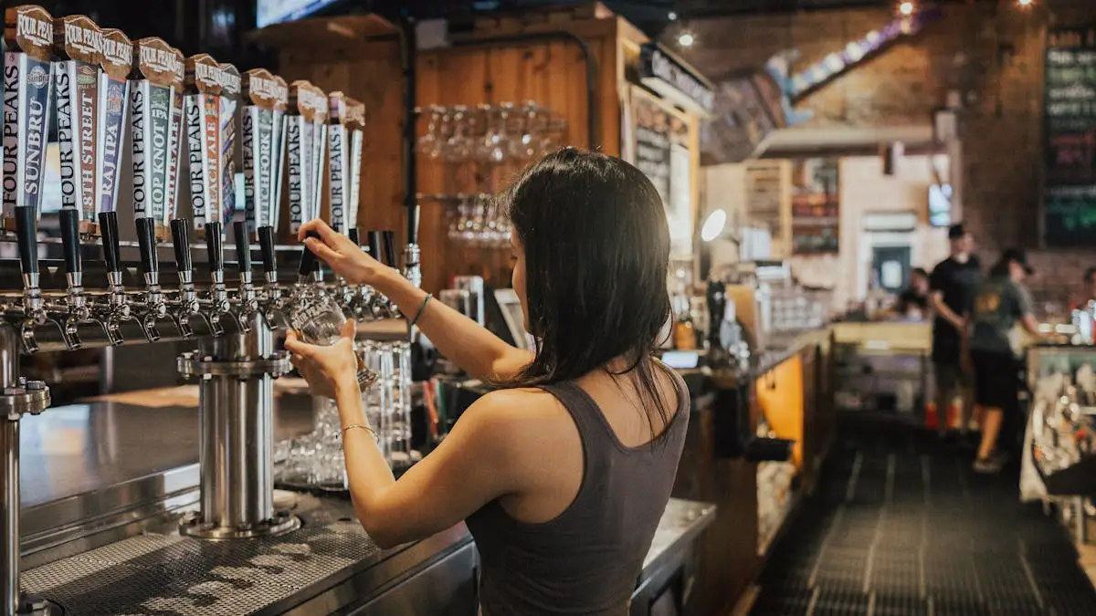 Barista woman pouring beer