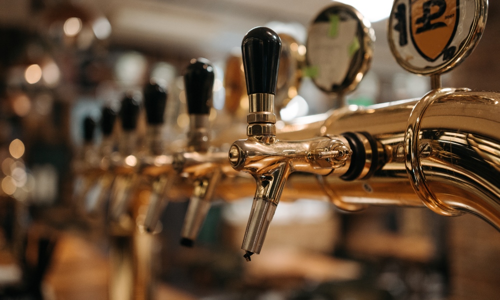view of a row of polished brass beer taps