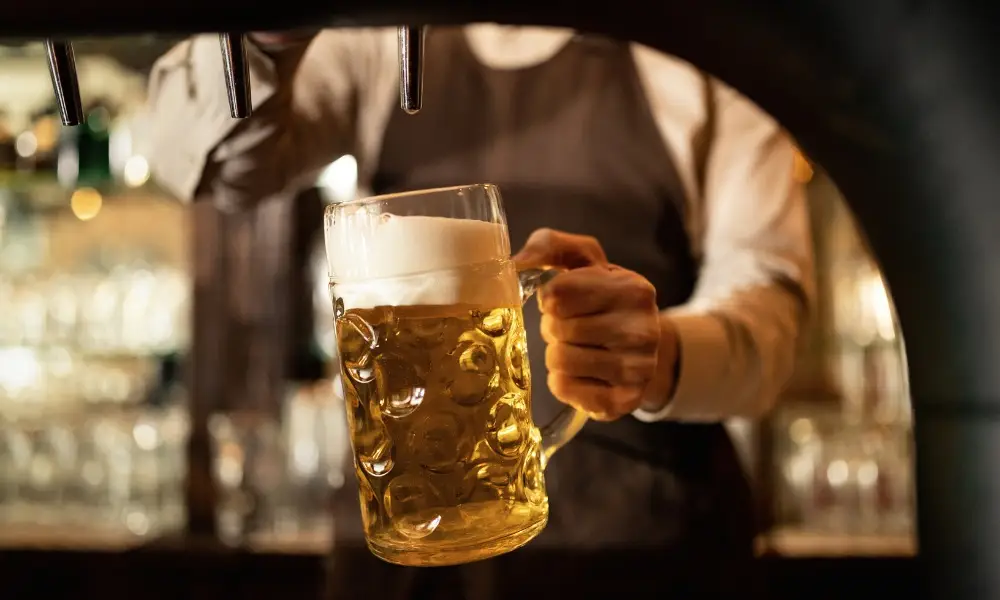 dimpled glass mug filled with foamy beer