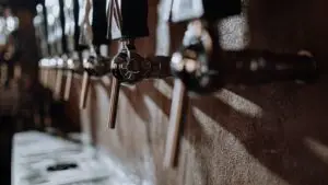 Close-up of beer taps in a cozy bar with warm lighting, showing texture and quality
