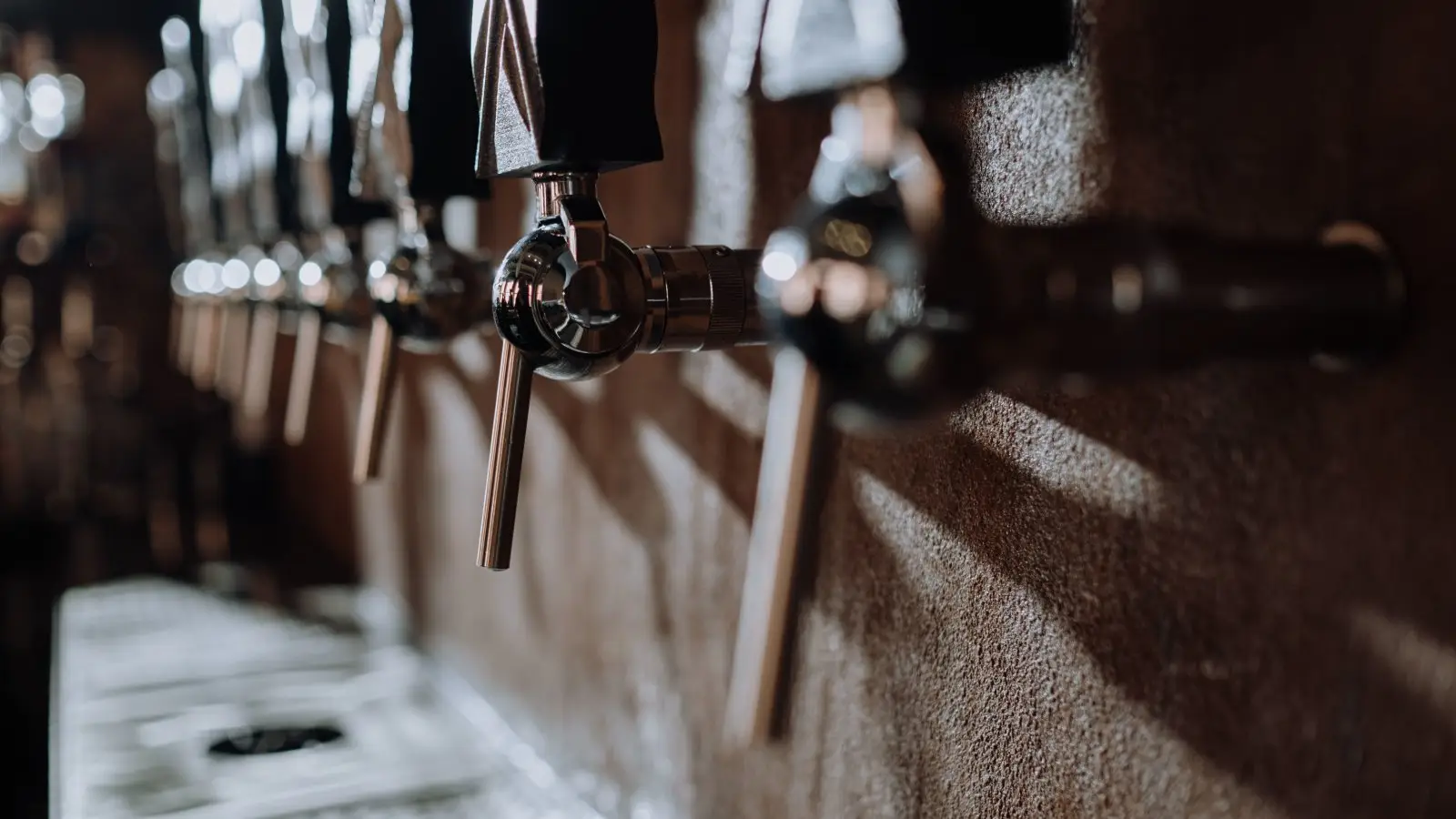 Close-up of beer taps in a cozy bar with warm lighting, showing texture and quality