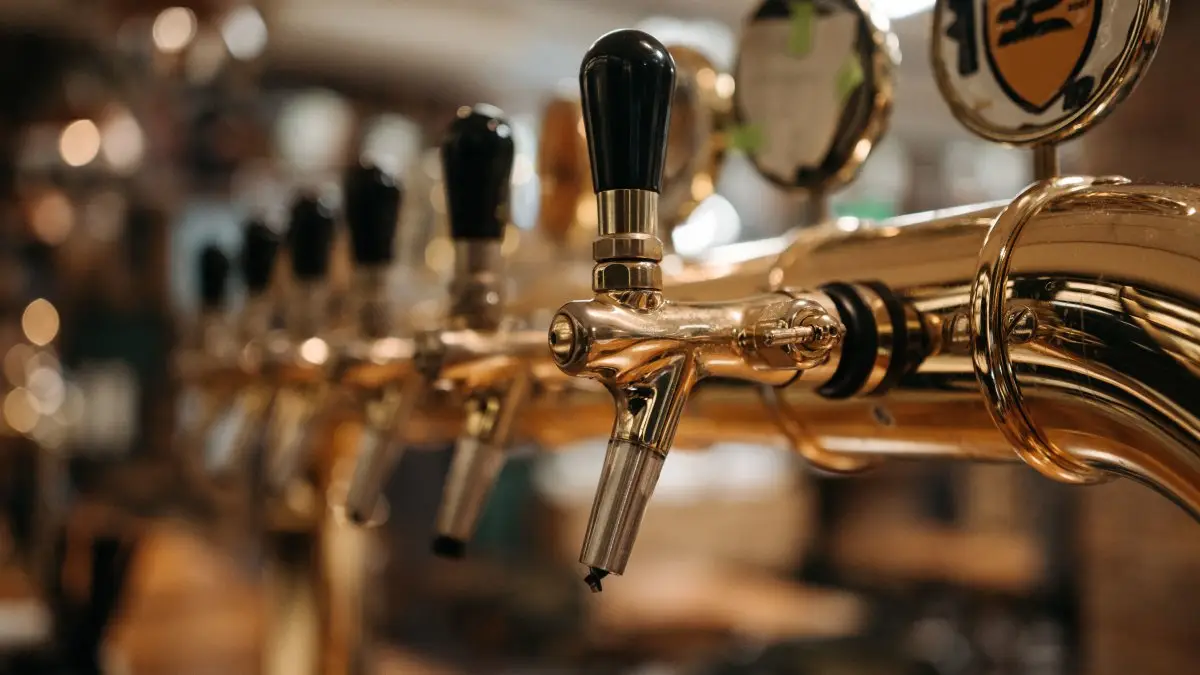 Shiny beer taps in a bar with a warm, inviting atmosphere