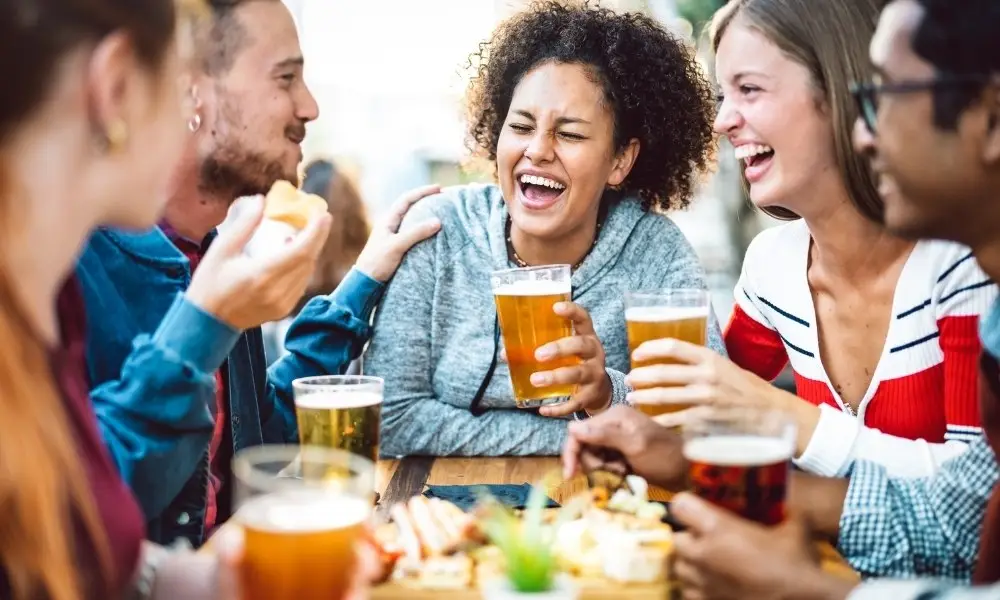 A group of friends laughing together at an outdoor bar