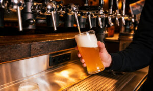 Bartender pouring light, cold foamy beer