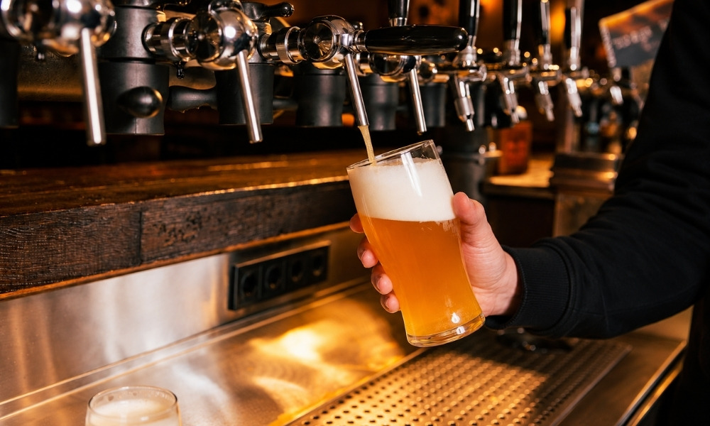 Bartender pouring light, cold foamy beer